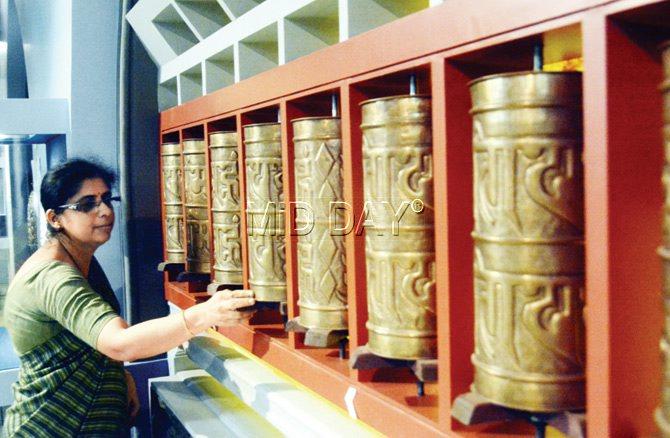 Manisha Nene, assistant director, turns a set of prayer wheels at the gallery. The purpose is to make the gallery interactive and accessible to all kinds of visitors, some who may not have had a chance to visit Nepal or Leh