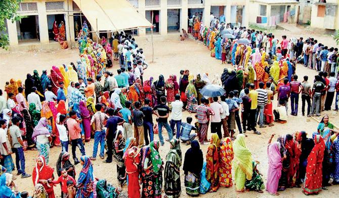 Voters stand in a long queue to cast their votes at a polling station in Bankura, West Bengal. 