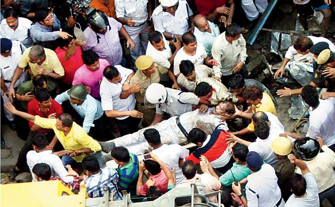 An injured traffic police personnel is shifted to an ambulance. PICS/PTI