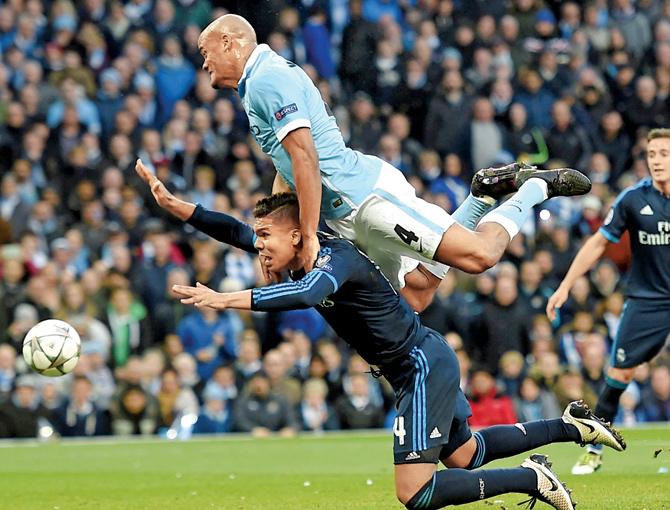 Man City’s Vincent Kompany (top) clatters into Real Madrid’s Casemiro during the Champions League semis first-leg match at the Etihad Stadium in Manchester on Tuesday. Pic/AFP