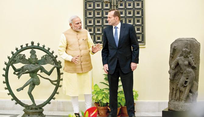 Indian Prime Minister Narendra Modi speaks with his Australian counterpart Tony Abbott, flanked by the Nataraja idol and the Ardhanariswara statue prior to a delegation level meeting in New Delhi on September 5, 2014. PIC/AFP 