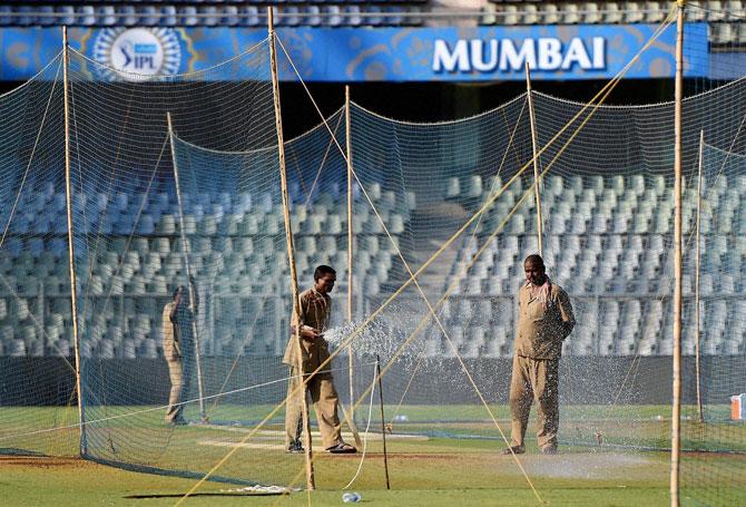 Groundsmen water the pitch at the Wankhede stadium ahead of IPL matches in Mumbai on Wednesday, even as the Bombay High Court today said ideally IPL matches should be shifted elsewhere, where there is no water crisis. PTI