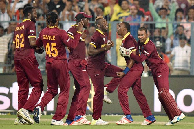 Chris Gayle, Darren Sammy, Andre Russell and Dwayne Bravo celebrate the fall of an English wicket during the World T20 final.