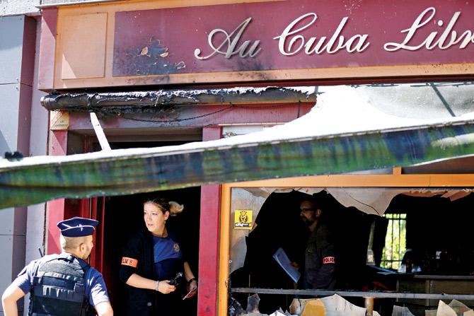 Police officers inspect the damaged Au Cuba Libre bar in Rouen, after a fire broke out in the bar during a birthday party on Saturday. Pic/AFP