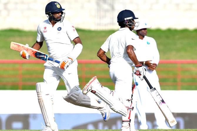 Ravichandran Ashwin (L) and Wriddhiman Saha (R) of India partnership during day 1 of the 3rd Test between West Indies and India August 9, 2016 at Darren Sammy National Cricket Stadium Gros Islet, St. Lucia. Pic/AFP
