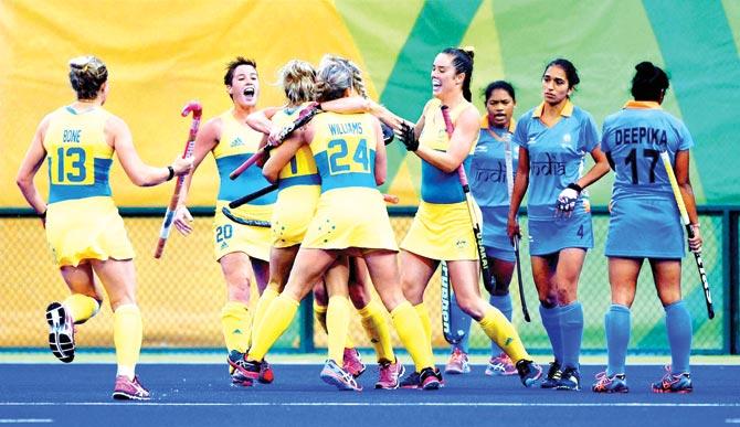 Australians celebrate a goal as Indian players look on during a hockey match in Rio yesterday. Pic/AFP