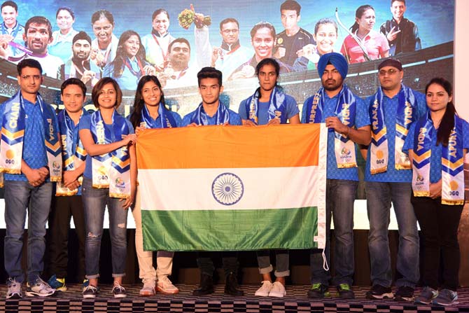 Indian athletes pose along with national flag during an event. File pic