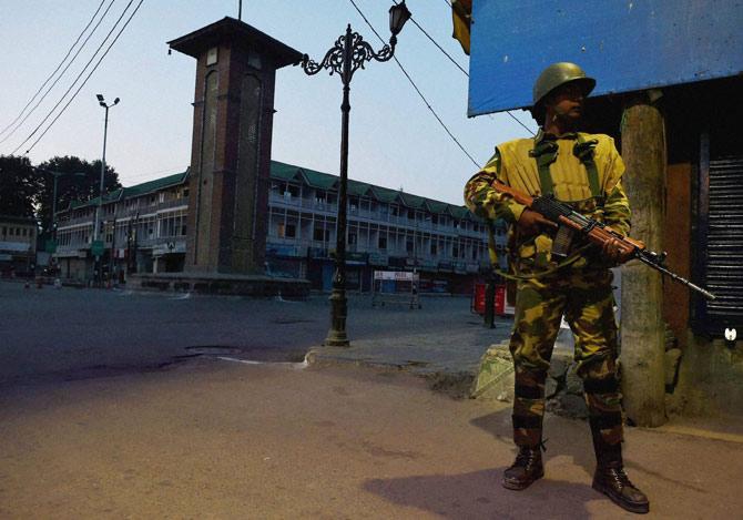 A security jawan stands guard during night curfew