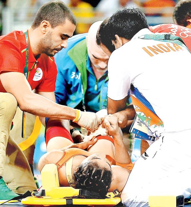 Indian wrestler Vinesh Phogat is stretchered off after suffering an injury on Wednesday. Pic/PTI