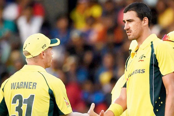 Warner congratulates Starc after a wicket during the 1st ODI yesterday. PIC/AFP