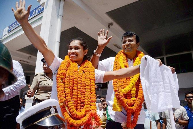 Gymnast Dipa Karmakar and her coach BS Nandi being accorded warm welcome upon their arrival at the Agartala airport. Pic/ PTI