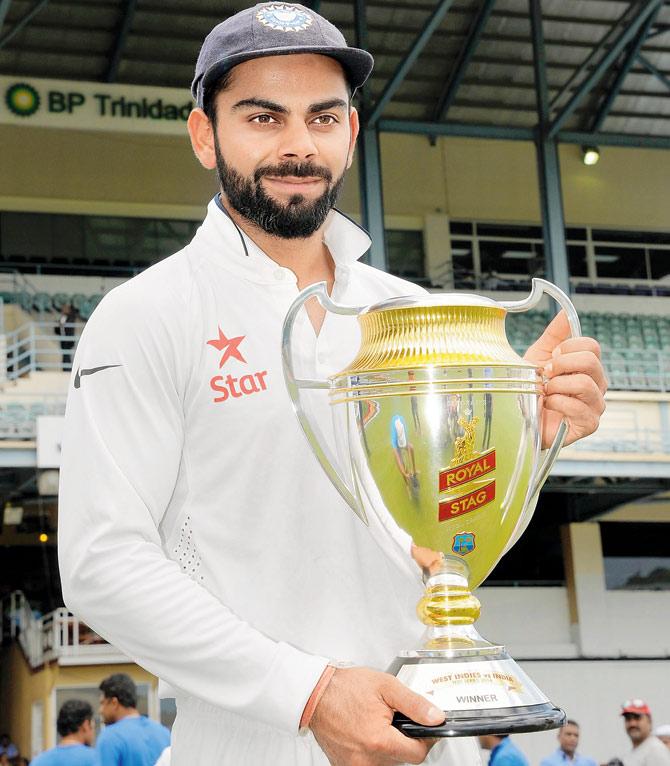 India skipper Virat Kohli holds the series trophy at Queen’s Park Oval in Port of Spain yesterday. Pic/AFP