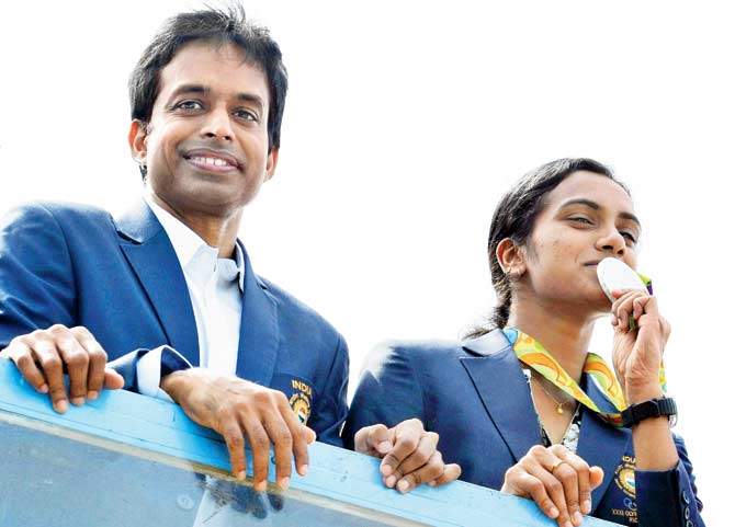 Rio Olympics silver-medallist PV Sindhu (right) and coach Pullela Gopichand take part in a parade after arriving in Hyderabad yesterday. PIC/pti