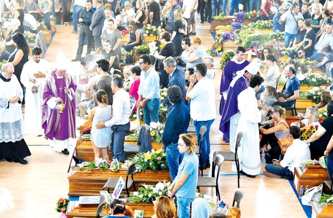 People attend a mass funeral service for victims of the earthquake, at a gymnasium arranged in a chapel in Ascoli Piceno. Pic/AFP