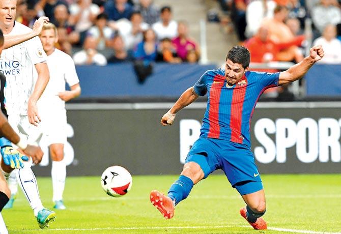 Barcelona forward Luis Suarez shoots to score his team