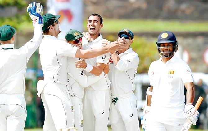 Australia pacer Mitchell Starc (centre) celebrates the wicket of SL