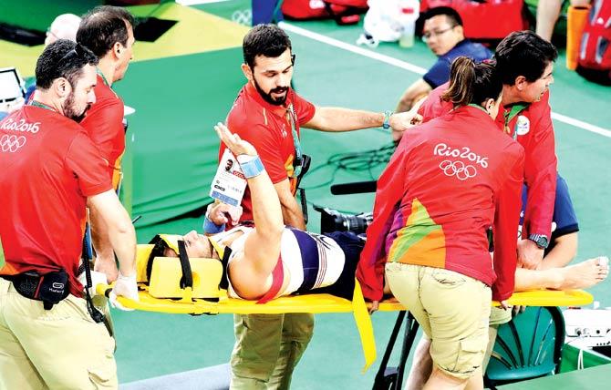 Samir Ait Said waves to crowd even as he is stretchered from the hall after his fall