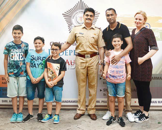 Jamil Meusen — with his children, Isar, Jay, Ravi, Milan and wife Kelly — interacts with senior police inspector Nitin Bangale at the Dongri Police Station. Pic/Satej Shinde