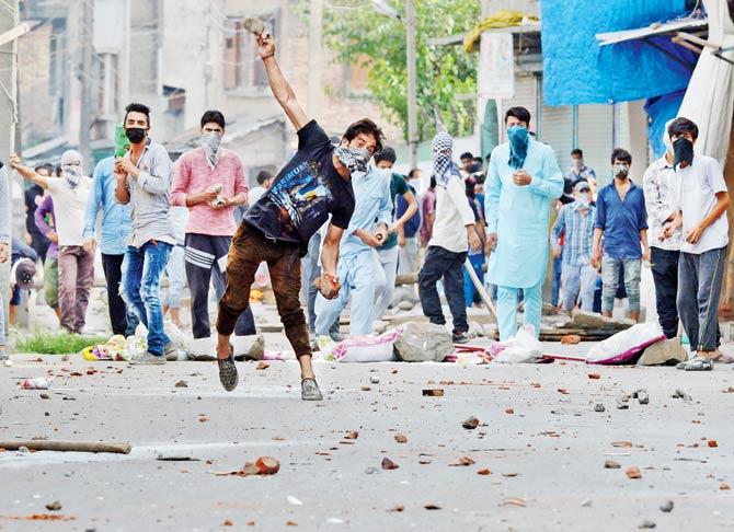 Kashmiri protesters hurl stones at security forces during an agitation against civilian killings in Srinagar yesterday. Pic/AFP