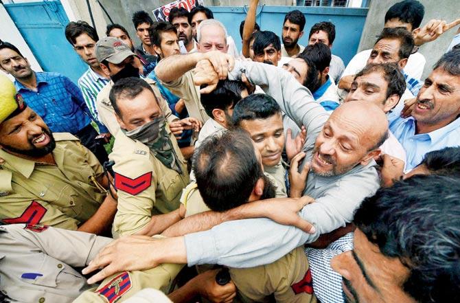 J&K police stop MLA Sheikh Abdul Rashid and members of Awami Itihaad Party who were holding a protest march against civilian killings, in Srinagar yesterday. Pic/PTI