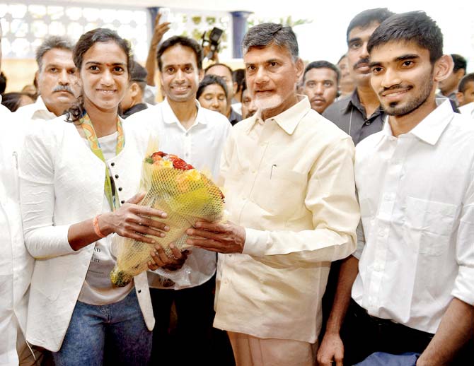 Chief Minister of Andhra Pradesh N Chandrababu Naidu felicitates Olympic silver medalist PV Sindhu in Vijayawada on Tuesday. Also seen are her coach Pullela Gopichand and fellow shuttler Srikanth Kidambi (R). Pic/PTI