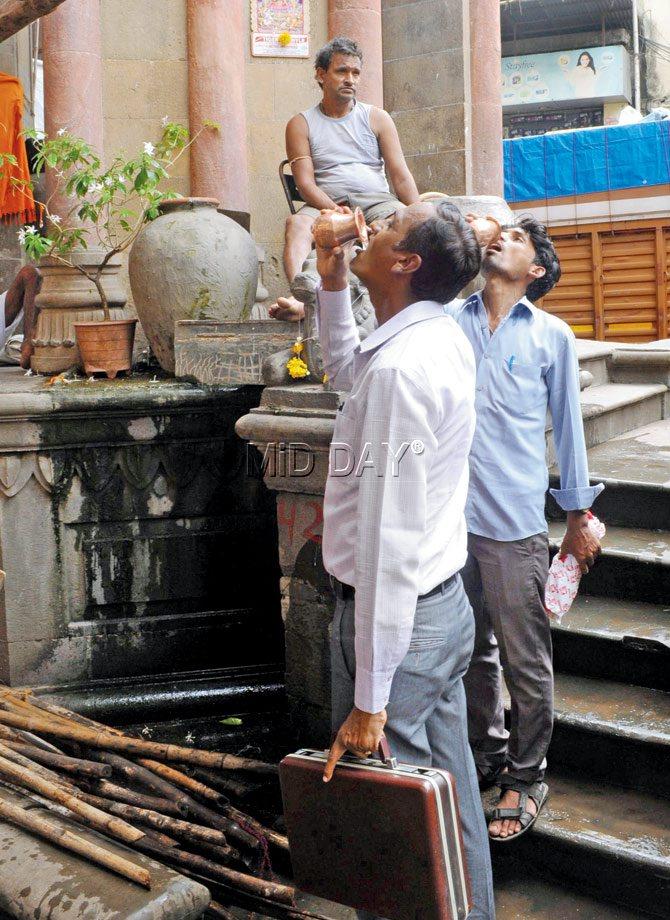 Passersby quench their thirst at the only functioning heritage pyau in  the city. Pic/Datta Kumbhar 