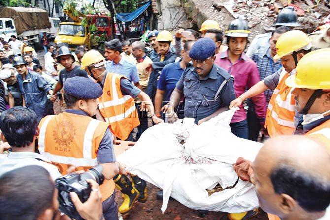 Rescue personnel recover the body of a victim from the rubble and Rescue operations on at the site of the building collapse in Bhiwandi. They lasted 12 hours