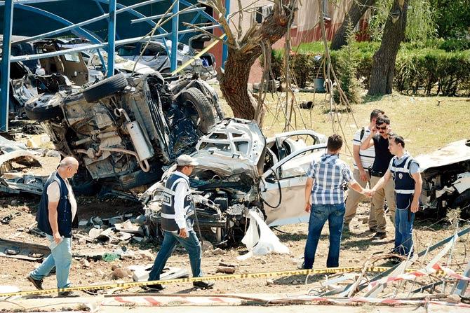 Turkish rescue workers and police inspect the blast scene after a car bomb attack on a police station in Elazig. Pic/AFP