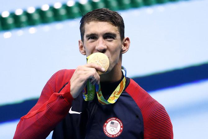 Michael Phelps kisses his gold medal.