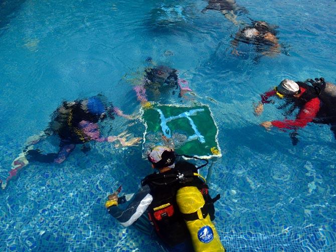 These pictures show mahjong enthusiasts playing mahjong under water in a swimming pool at a diving club in the Chinese city of Chongqing