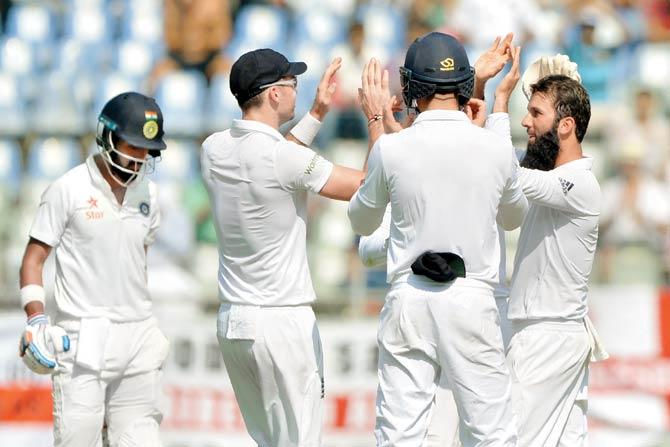 England’s Moeen Ali (right) celebrates with teammates after dismissing India opener Lokesh Rahul (left) on the second day of the fourth Test at the Wankhede Stadium in Mumbai yesterday. India did not lose another wicket during the day. Pic/AFP