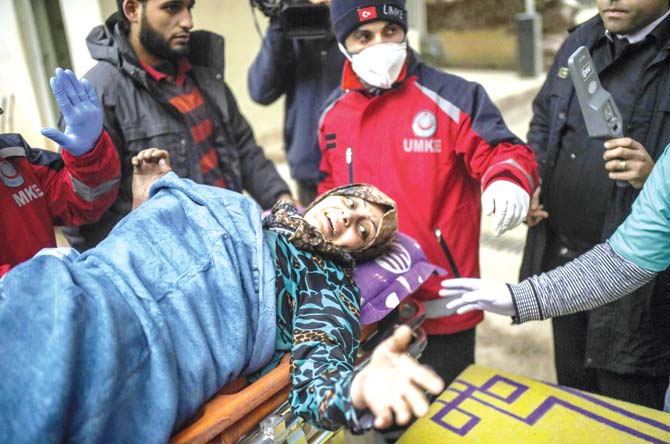 An injured Syrian woman from Aleppo reacts while being transported from the Syrian side of the Bab al-Hawa border crossing to a hospital in Turkey on Friday. Pic/AFP