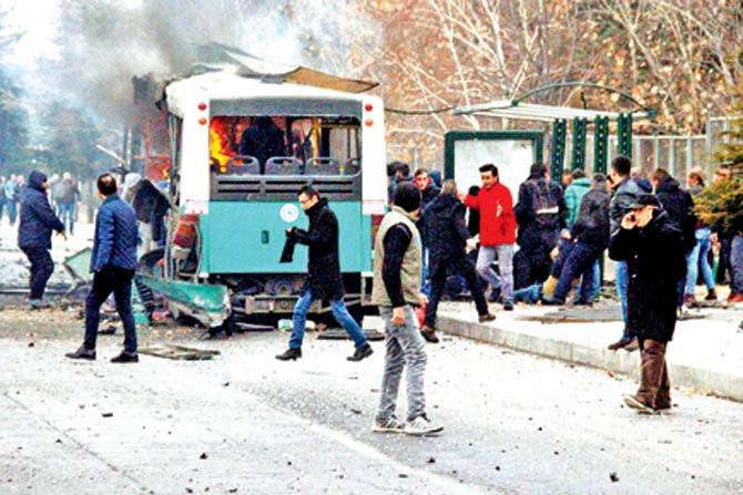 People walk next to the wreck of public bus following an explosion on Saturday in Kayseri, central Turkey. Pic/AFP