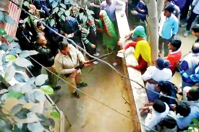 Video grab of people throwing slippers at the cop outside PNB in Bulandshahr on Saturday