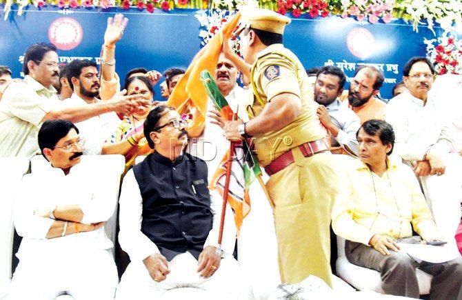 DCP Deepak Devraj collects flags from BJP and Shiv Sena workers as Railway minister Suresh Prabhu and others on the dais look on. Pics/Nimesh Dave 