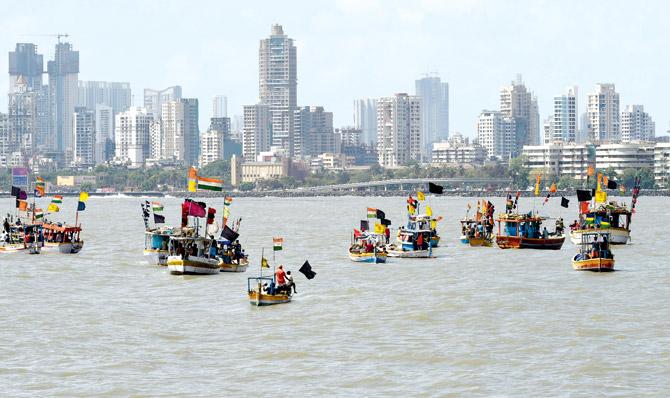 Fishing boats with black flags take part in a 