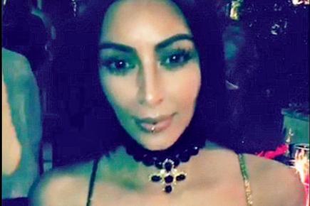 Kim Kardashian shows off her new lower lip piercing at Christmas bash