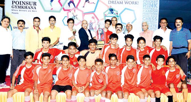 St Lawrence High School (Kandivli) players pose while receiving the winners trophy from the former Indian Railways footballer and coach, Ajit Matkat and vice president of the Poinsur Gymkhana, Karunakar Shetty yesterday