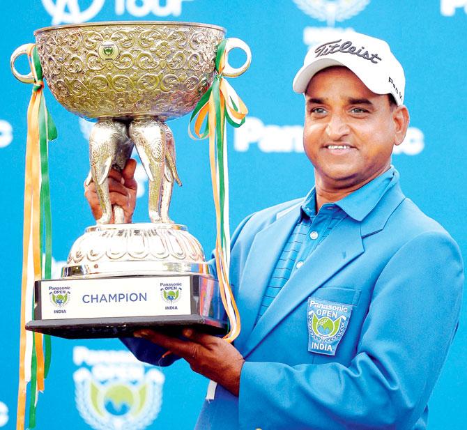 Indian golfer Mukesh Kumar poses with the trophy after winning the Panasonic Open in New Delhi yesterday. Pic/PTI