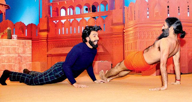 Ranveer Singh does yoga with Baba Ramdev at an event in Delhi on Tuesday evening . Pic/PTI