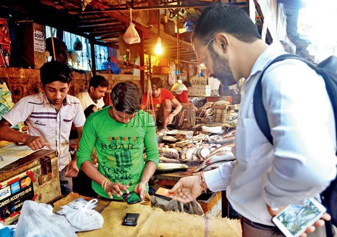 Abhishant Pant makes a debit card transaction at Bengali Fish Centre near IIT Powai. The vendor has invested in an mPOS machine that connects to a smartphone via bluetooth and accepts card payments. Pics/Datta Kumbhar
