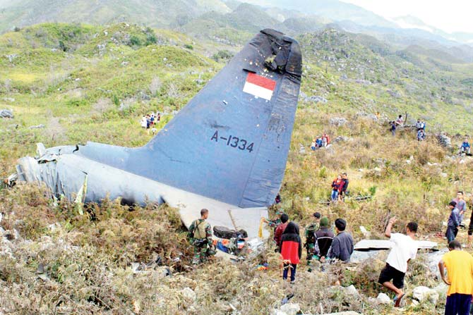 Rescuers at the site where an Indonesian Air Force plane that crashed in Wamena. Pic/AP/PTI