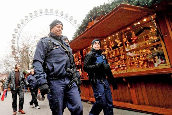 Police officers patrol a Christmas market near the city hall in Berlin on Wednesday. Pic/AP/PTI