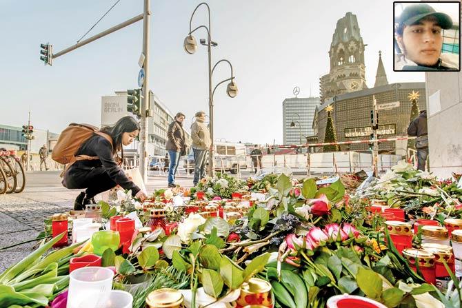 A mourner places a candle at a makeshift memorial near the church in Berlin on Wednesday pic/afp; (inset) suspect Anis Amir