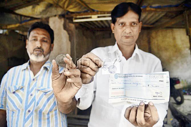 Power loom seths Muzammil Momin and Rehan Momin show tokens and cheques from the day’s wait outside two banks. They were told to come the next day to change and withdraw Rs 4,000 and Rs 2,000 respectively. They state that unless they get change, they will not be able to pay their labourers
