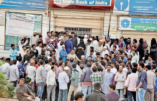 Citizens protest the unavailability of cash at a bank in Hyderabad on Friday. Pic/PTI