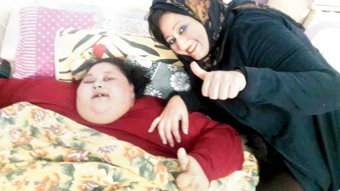 Eman Ahmad Abdulati, who has been bed-ridden for more than a decade, with her sister Shaimaa