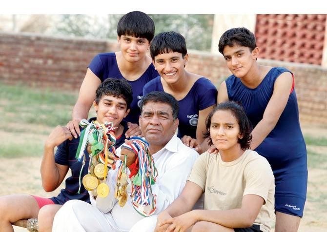 The Phogat sisters and their coach display their spoils