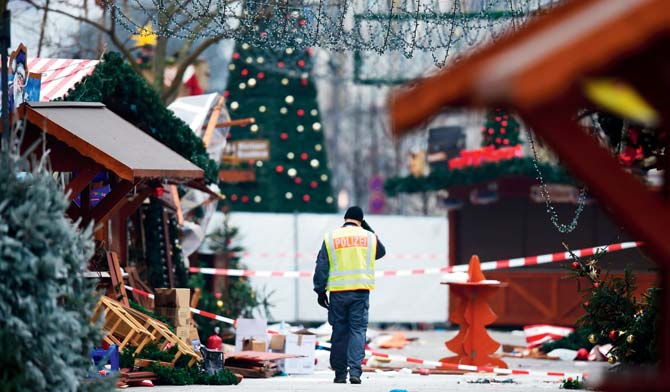 A policeman walks at the Christmas market near Kaiser Wilhelm Memorial Church on Tuesday. Pic/AFP