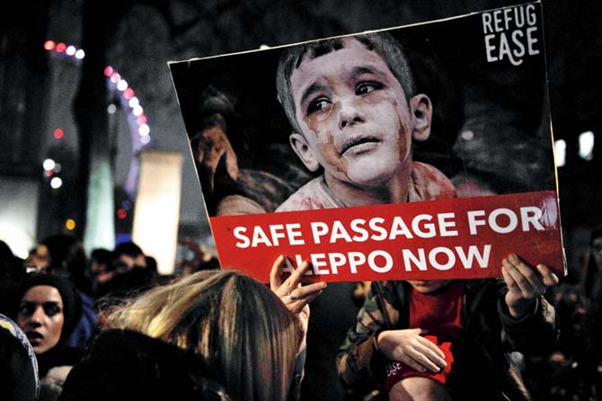 Protesters hold placards during a demonstration in solidarity with Aleppo residents, outside the entrance to Downing Street, in central London. Pic/AFP